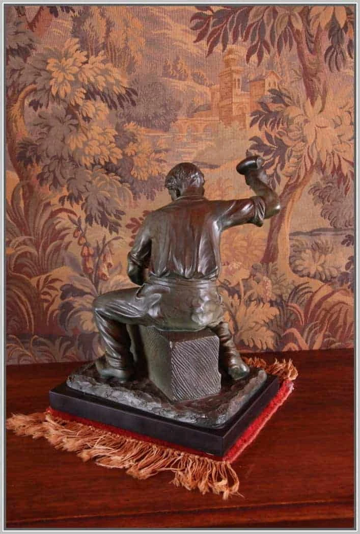 Patinovaná kovová socha na mramorovém podstavci