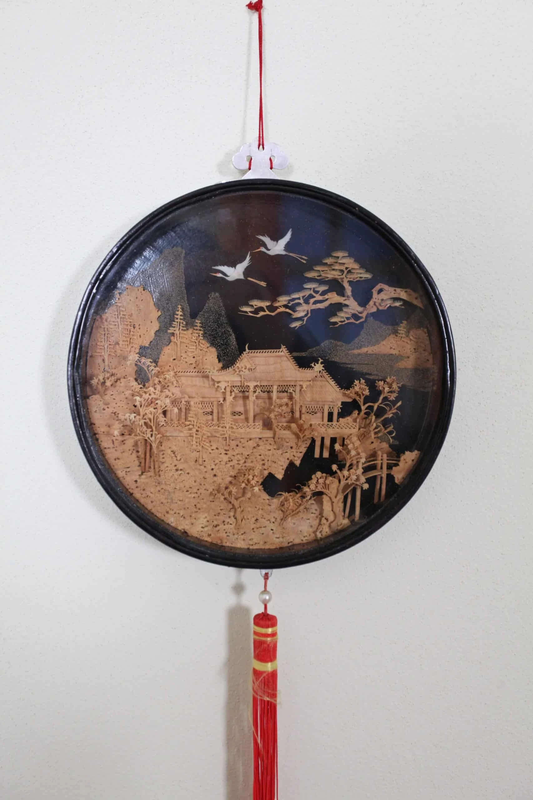 Kulatá dřevořezba paláce se stromy a ptáky